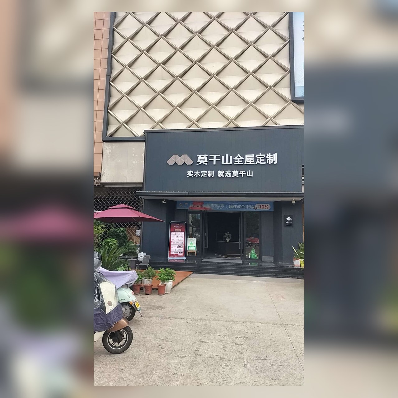 莫干山全屋定制绍兴门店门头实景：深灰招牌白色大字莫干山全屋定制，实木定制就选莫干山