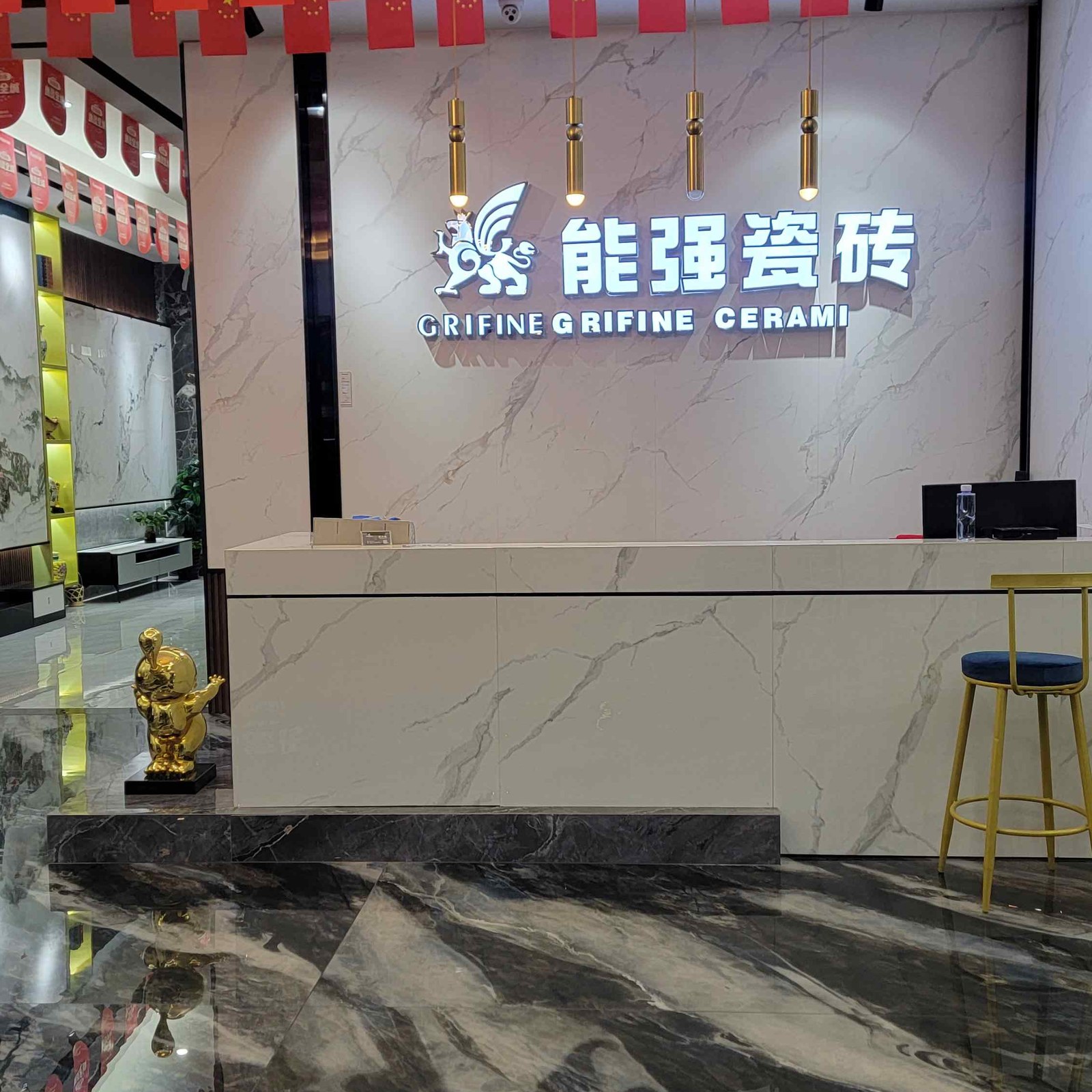 能强瓷砖店内前台形象墙：大理石背景墙配能强瓷砖GRIFINE发光logo，国庆国旗装饰