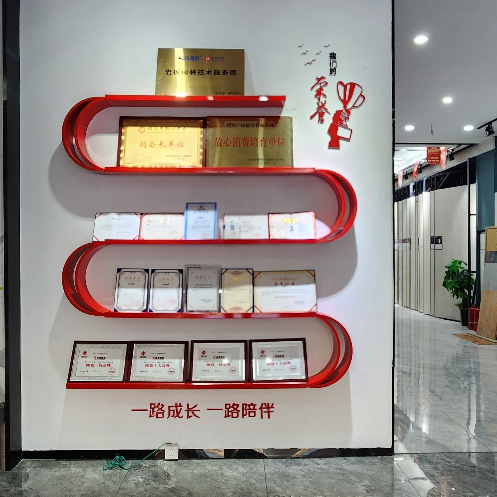 能强瓷砖荣誉墙：副会长单位、放心消费培育单位、岩板铺装技术服务商等荣誉牌匾