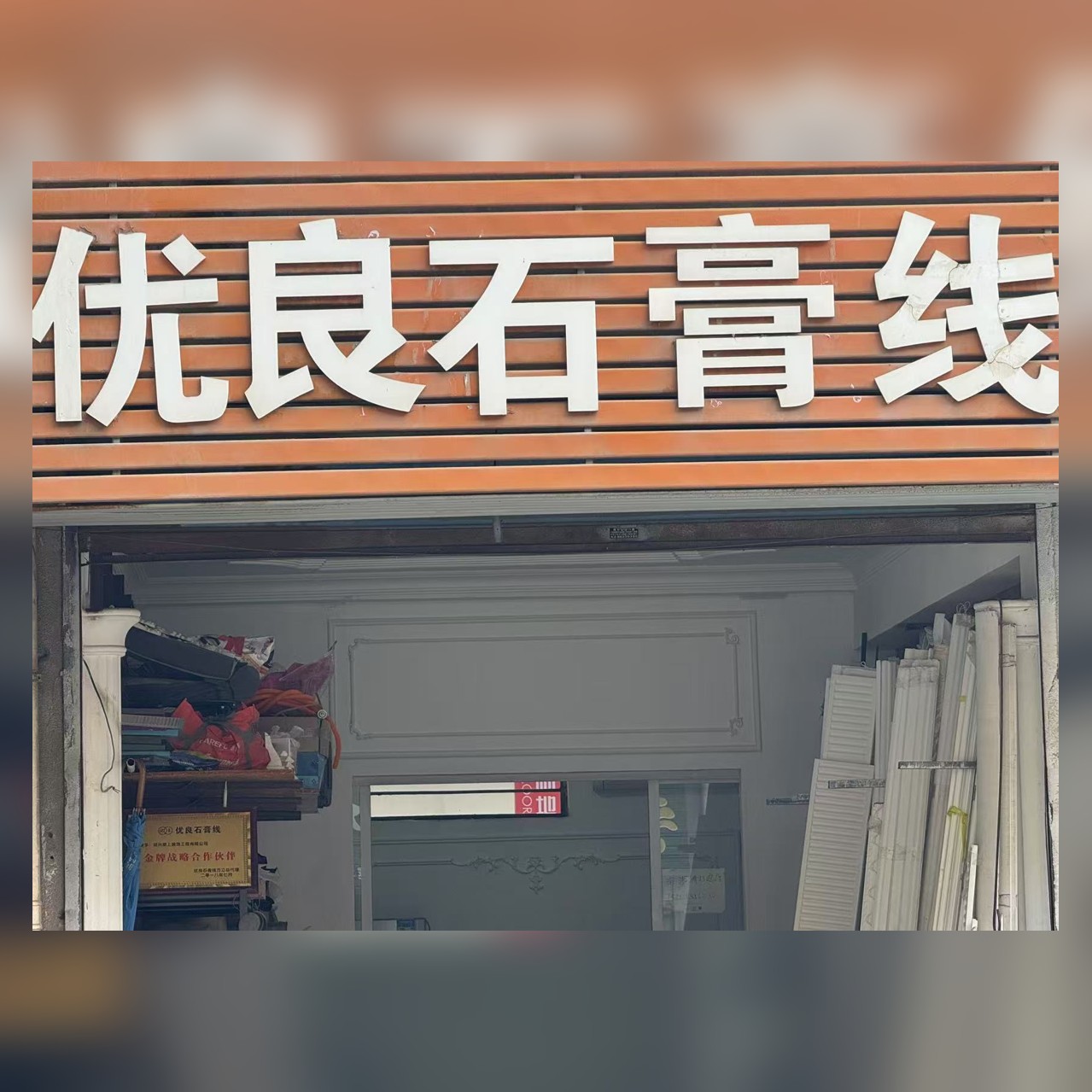 优良石膏线门店门头：橙色底白色立体大字招牌，新大城南门口朝皇路7号